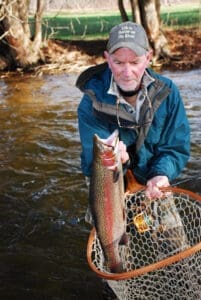 An angler with a colorful steelhead