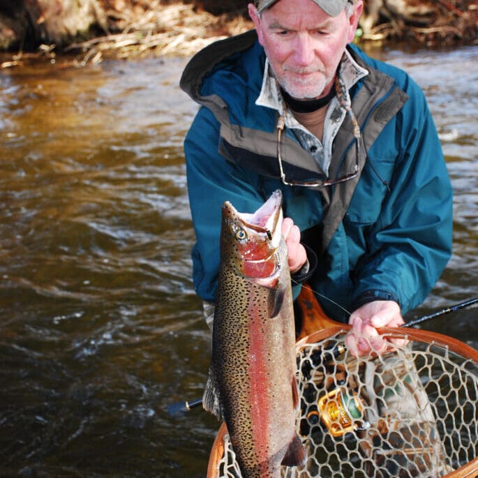 An angler with a colorful steelhead